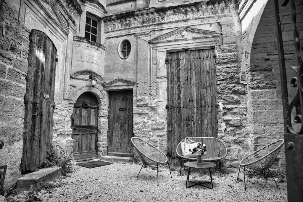 a group of chairs and a table in front of a building at Elegant apartment with balcony - Maison Comte in Uzès