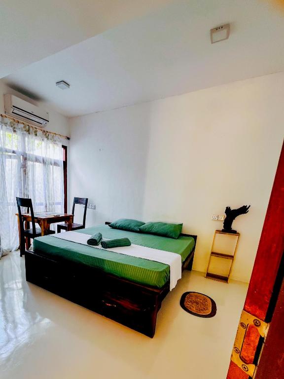 a bedroom with two beds and a cat sitting on a table at Footmark Surf Stay in Pottuvil