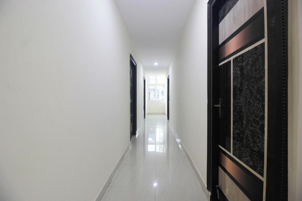 a hallway with black doors and a white floor at Collection O Stayo in Hyderabad