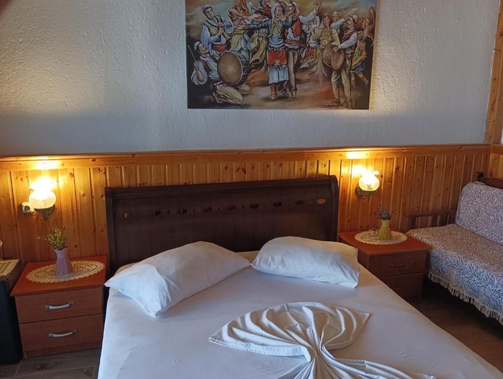 a bedroom with a bed and a painting on the wall at Guest House Bake in Gjirokastër