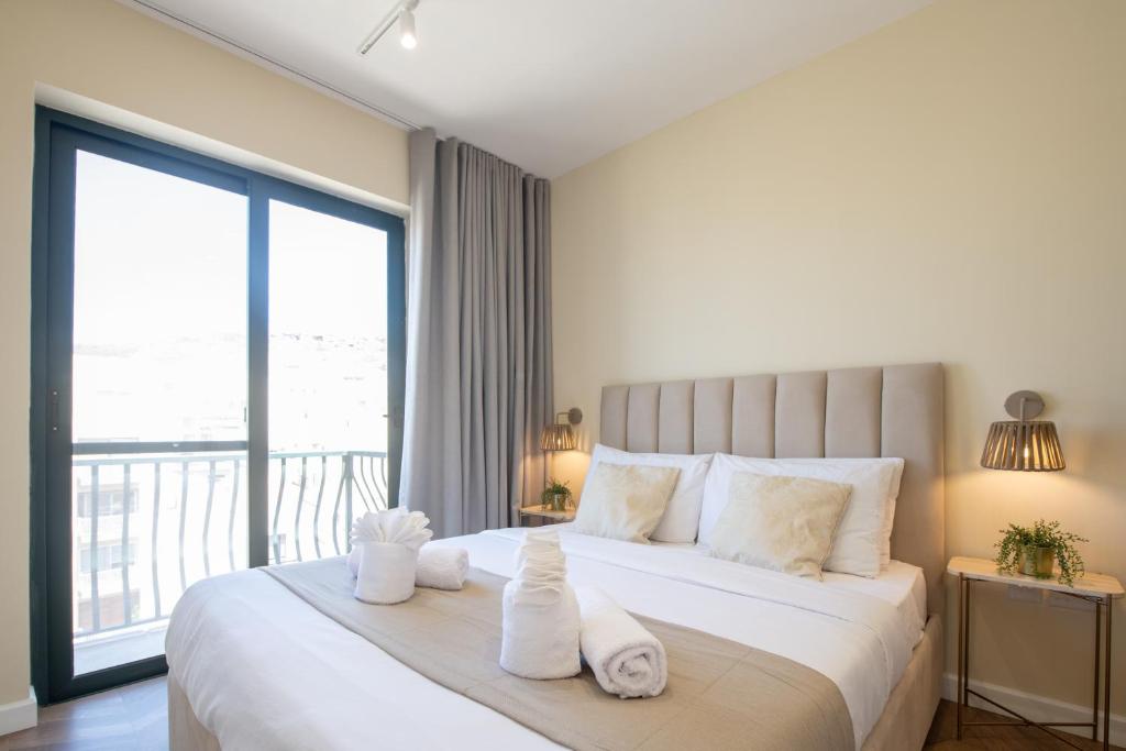 a bedroom with a large bed with towels on it at Electra Residence - Central Duplex Penthouse in Marsalforn