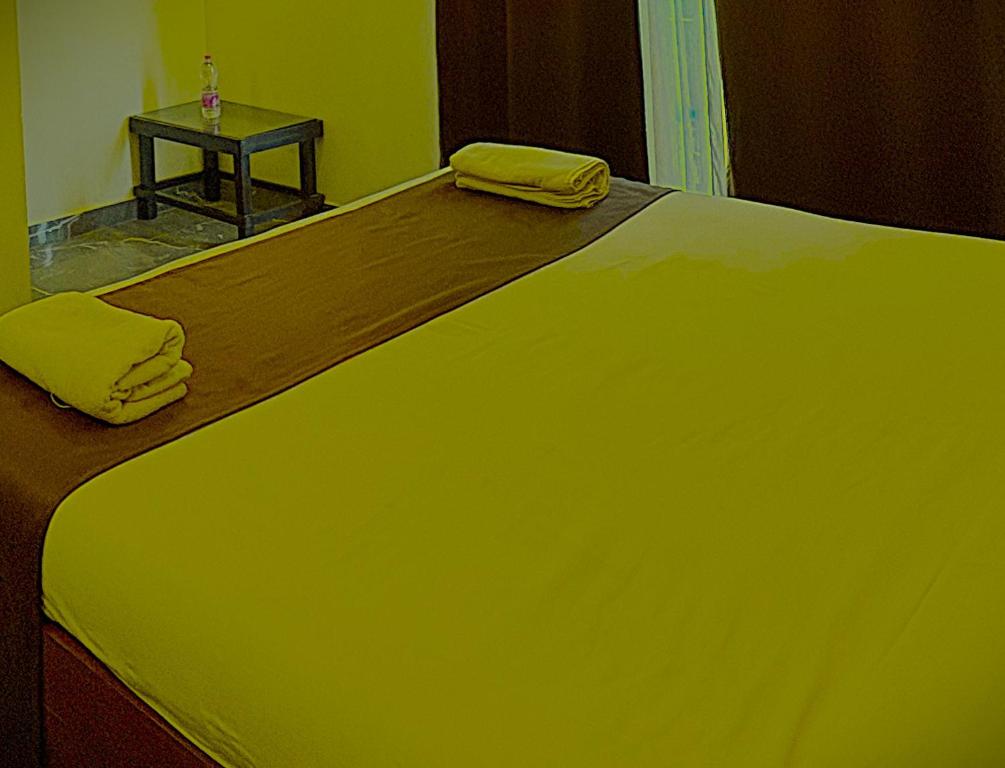 a large green bed with a table on top of it at Hotel krishna In Pokhran in Pokaran