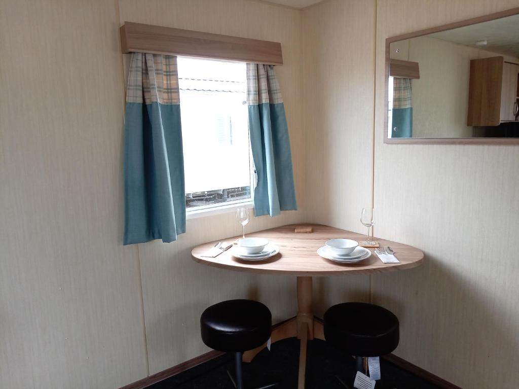 a small table with two chairs and a mirror at Elli-Roo's cabin in Hartley