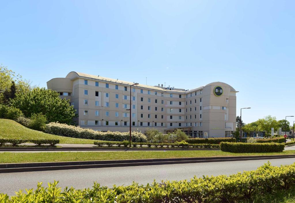 a large building with a road in front of it at B&B HOTEL Paris Roissy CDG Aéroport in Roissy-en-France