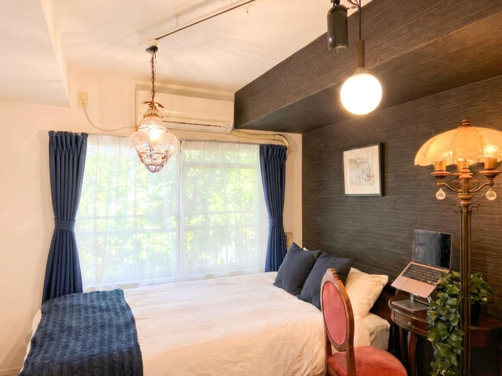 a bedroom with a bed and a window at Hachioji House 102 Apartment in Hachioji