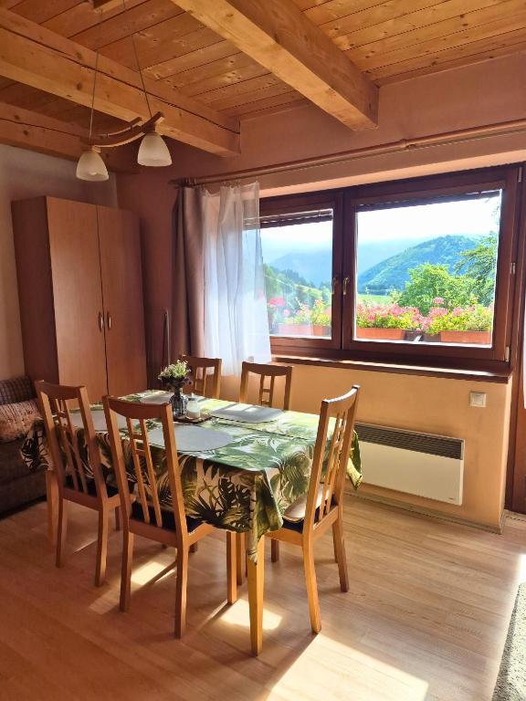 a dining room with a table and chairs and a large window at Apartmán Donovaly Mišuty 586 in Donovaly