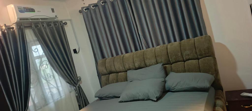 ein Schlafzimmer mit einem Bett mit Kopfteil und einem Fenster in der Unterkunft Harlington Duplex in Akitan