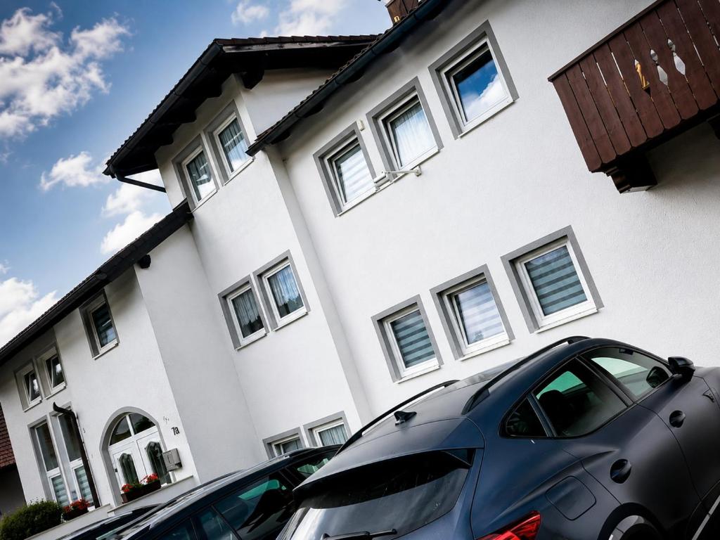 a car parked in front of a white house at MorNight in Spiegelau