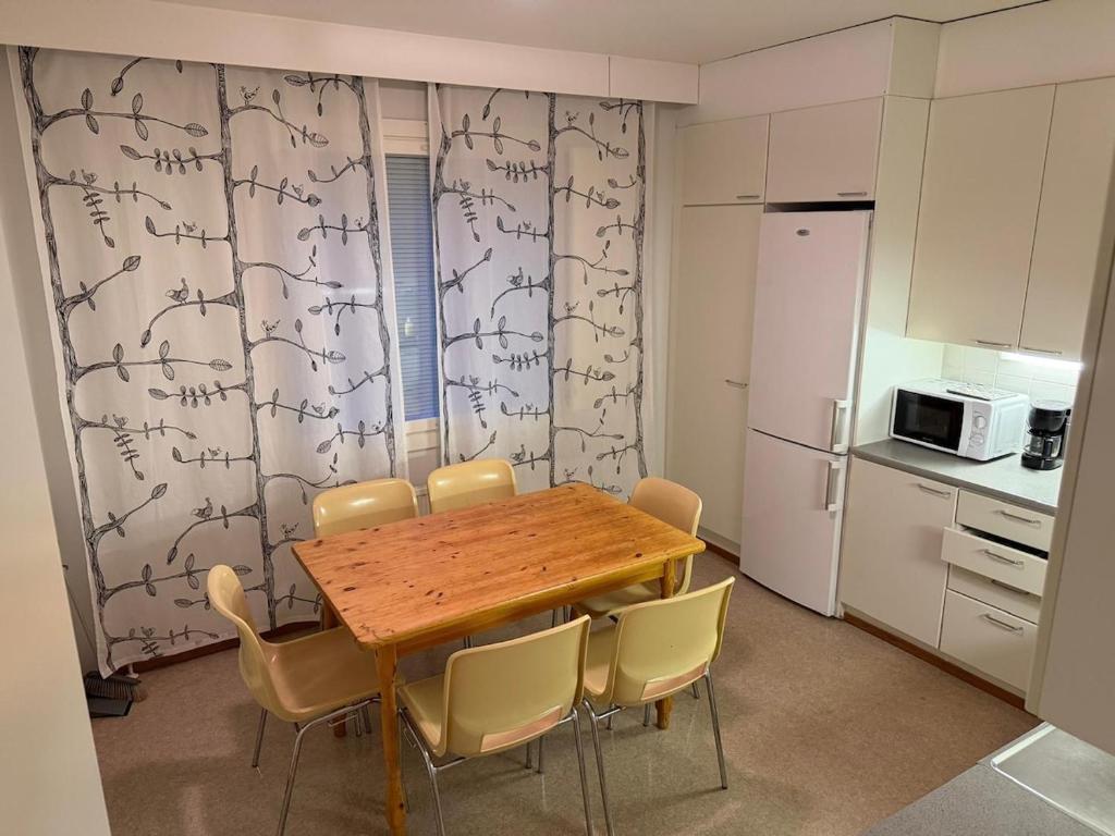 a kitchen with a wooden table and chairs in a room at LibO-apartment Porokylä 14 in Porokylä