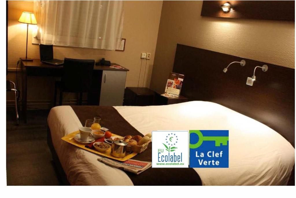 a hotel room with a tray of food on a bed at The Originals City, Hôtel Ascotel, Lille Est Grand Stade in Villeneuve d'Ascq