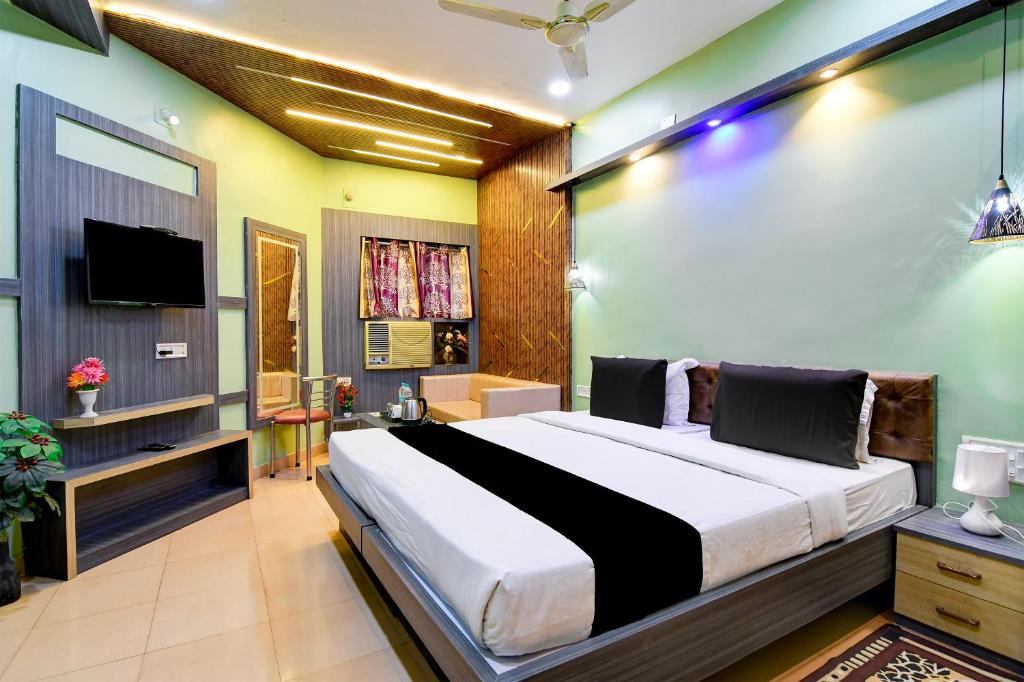 a bedroom with a large bed and a tv at Hotel Shree Krishna in Keonjhargarh