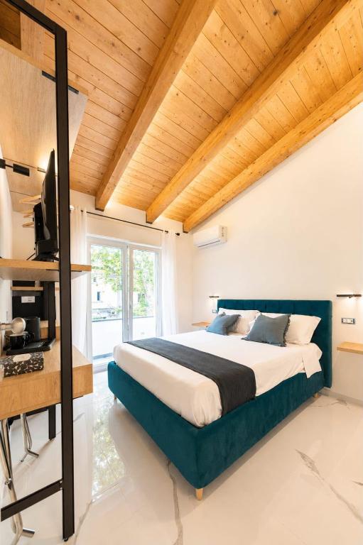 a bedroom with a large bed and a wooden ceiling at Casa Madrigale - radici e ritorni in Praia a Mare