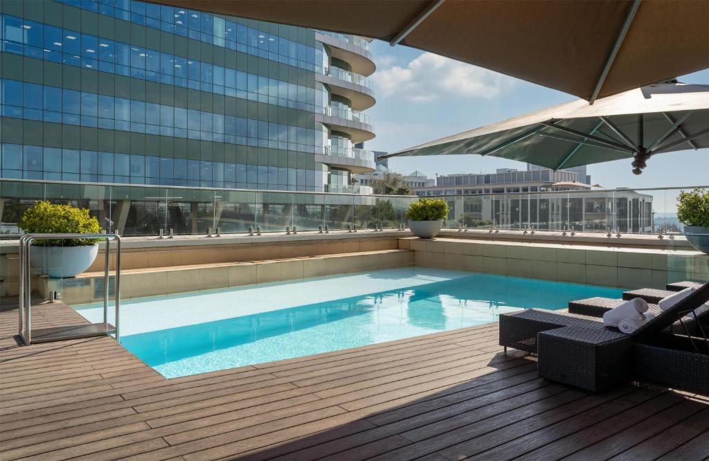 a swimming pool on the roof of a building at Radisson Blu Gautrain Hotel, Sandton Johannesburg in Johannesburg