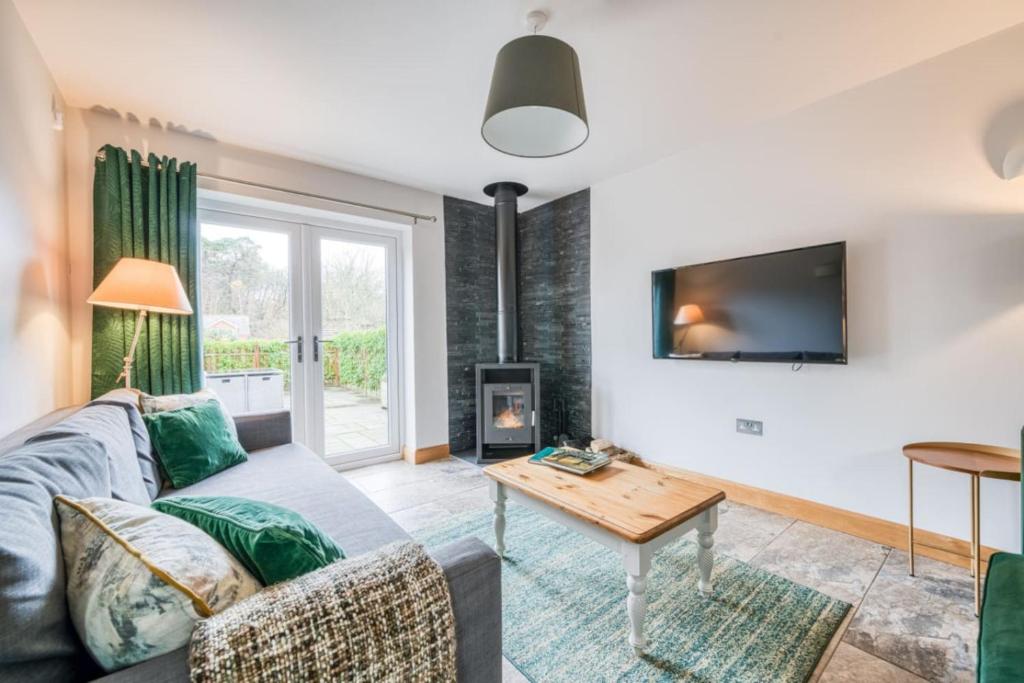 a living room with a couch and a tv at Luxury Cottage in the New Forest with Log Burner in Redlynch