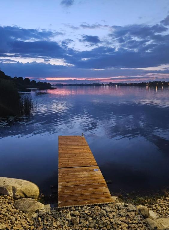 a dock in the middle of a body of water at Piestātne Riverside Cabins with Sauna, Hot Tub & Private Pier in Katlakalns