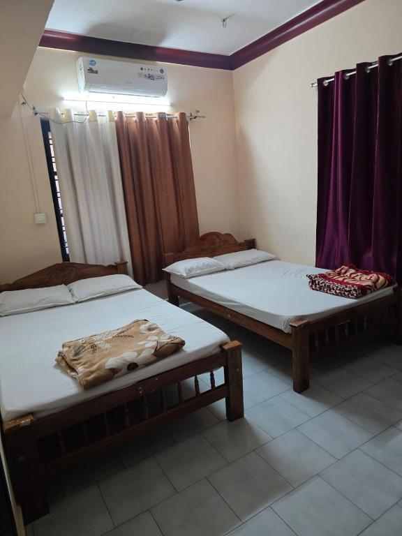 a room with two beds in a room at krishnageeth 4bedroom villa in Guruvāyūr