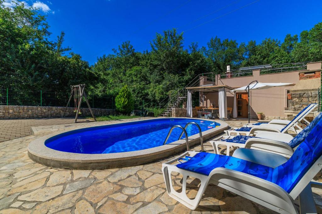 a pool with a bunch of chairs and a swimming pool at Villa Adry 2 in Bribir