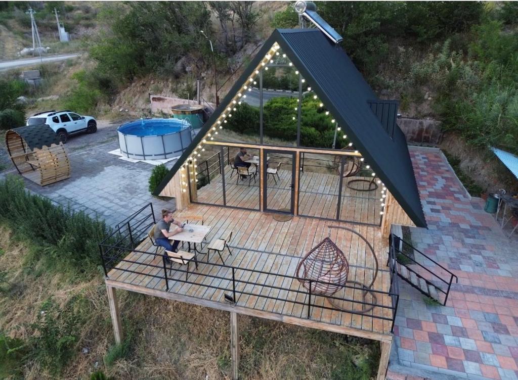 an overhead view of a house with a man sitting on a deck at Triangle house in Areni