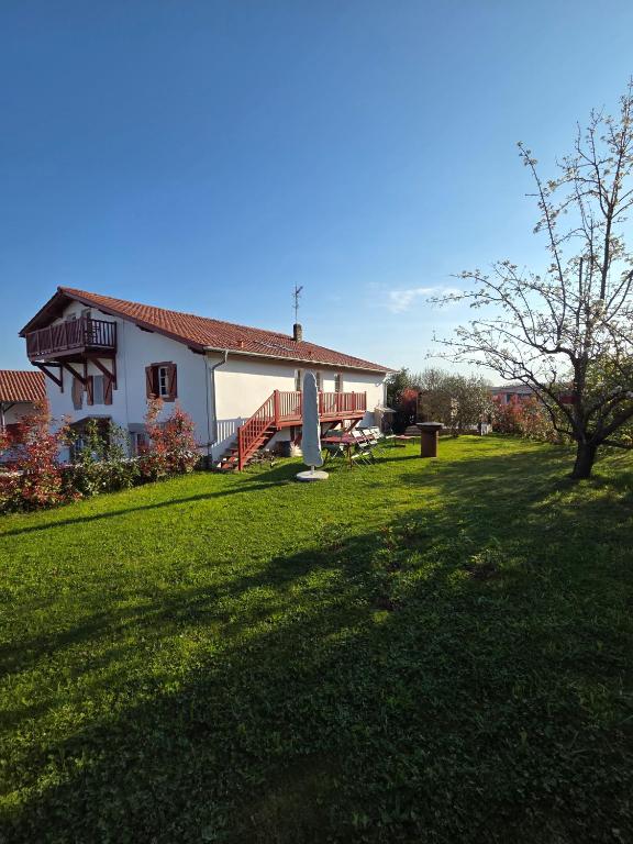 a house with a grassy yard next to a building at Chambre d'hôtes Ahetzina in Ahetze