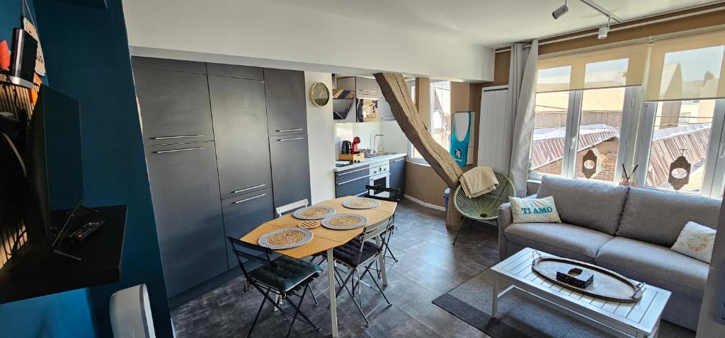 a small living room with a table and a couch at Le petit Rouen in Rouen