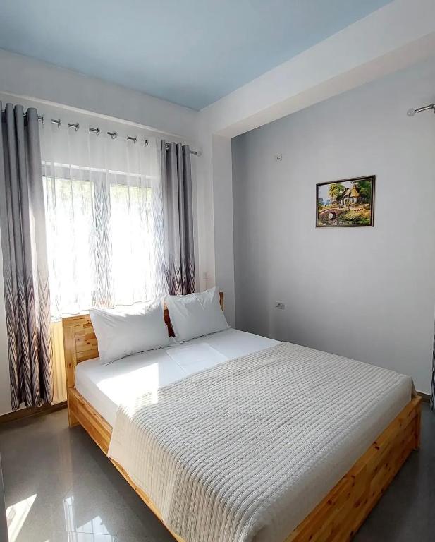 a bedroom with a large bed in a room at The White Villa - Guest House in Bogovë