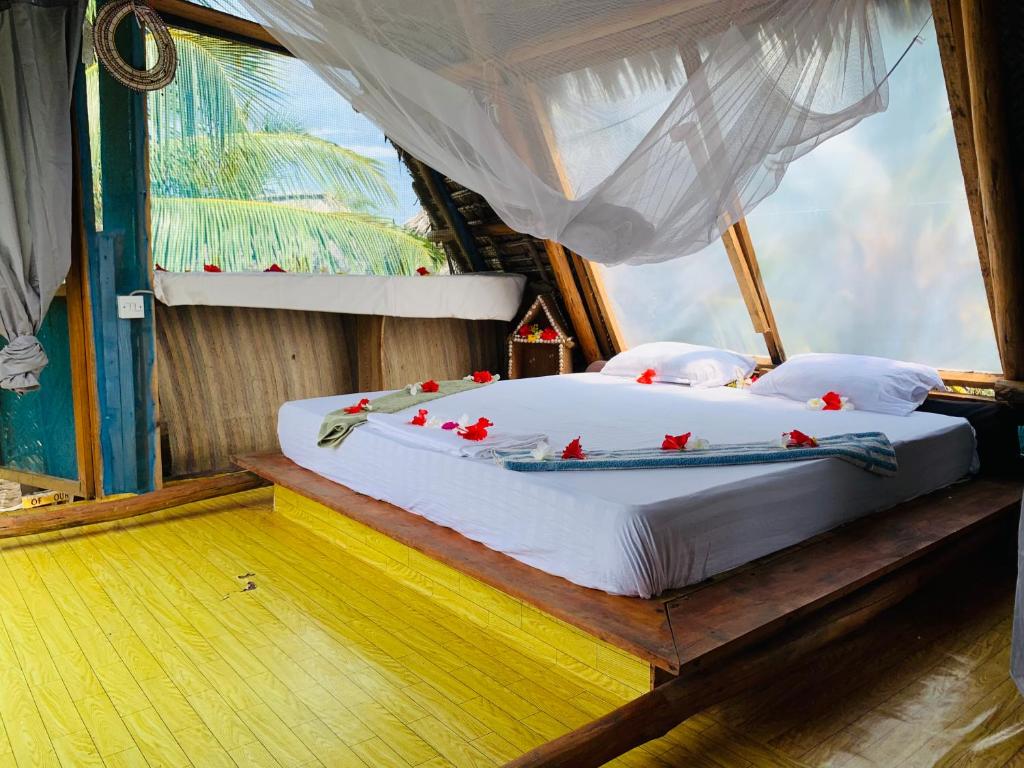 a bedroom with a bed with red flowers on it at Peace House Zanzibar in Bwejuu