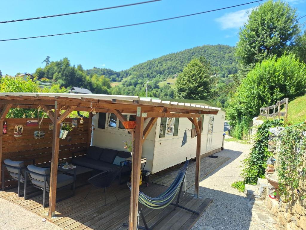 a rv with a couch and chairs under a roof at Lexi Zen House in Kamnik