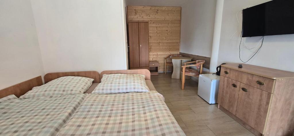 a bedroom with two beds and a dresser and a tv at Promyk 2 in Rewal