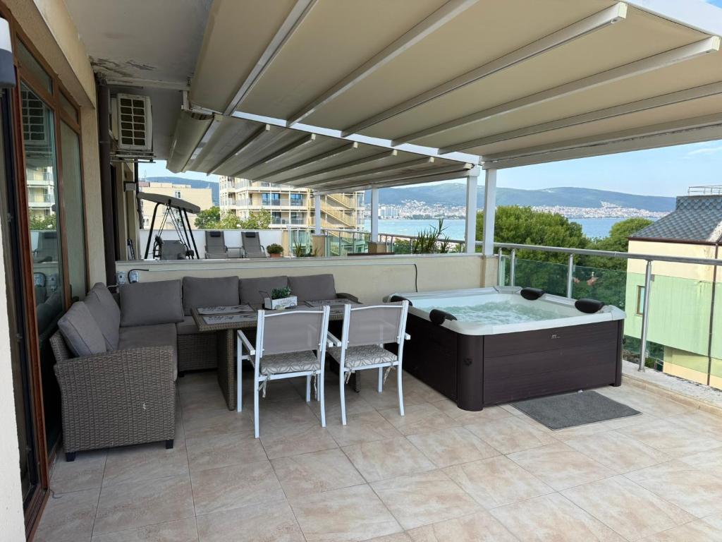 a patio with a table and chairs and a hot tub at YS Residence in Sunny Beach