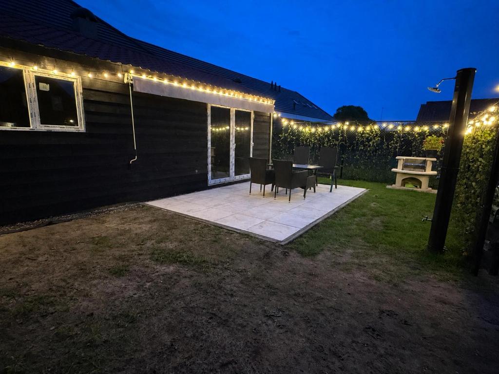 a patio with lights on the side of a house at B&B Tinkunakama in Ouddorp