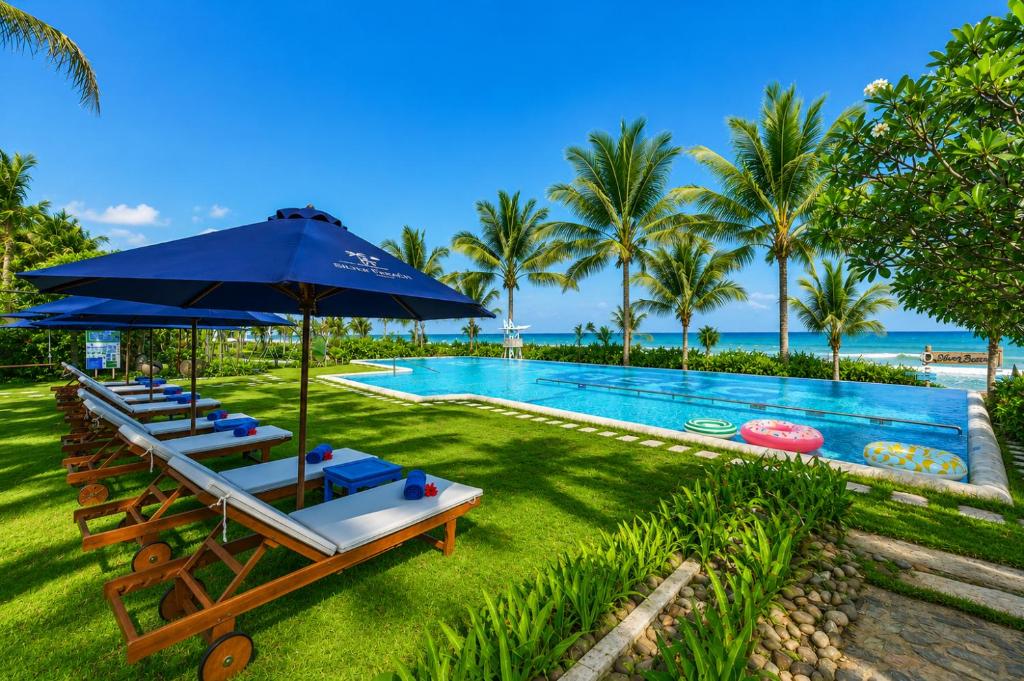 a pool with lounge chairs and an umbrella and a swimming pool at Silver Beach Resort Ke Ga in Ke Ga