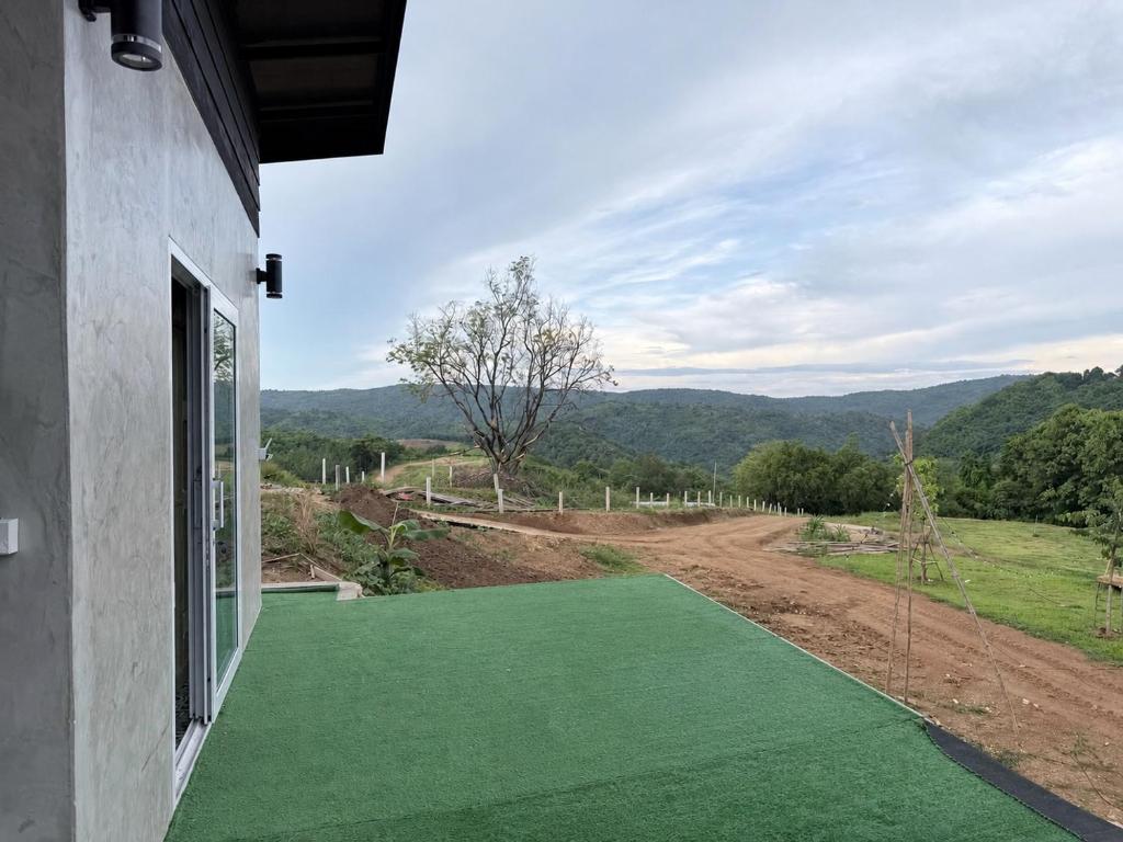 a view from a house with a green lawn at ภูหลงหมอก รีสอร์ท in Ban Huai Lat