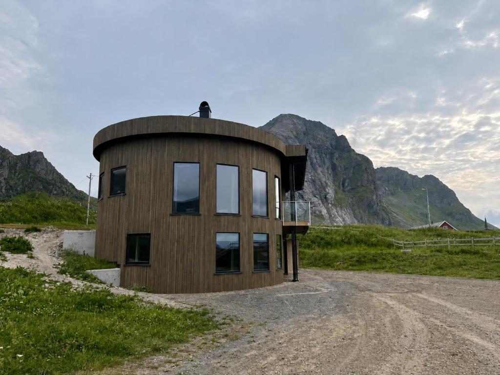 a round house on a dirt road in the mountains at Flakstad beach house Silo A in Vareid