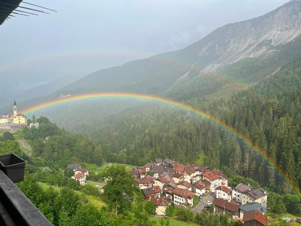 a rainbow over a city with a town with at Dolomites View Apartment - Mountain Relax Experience in Cibiana