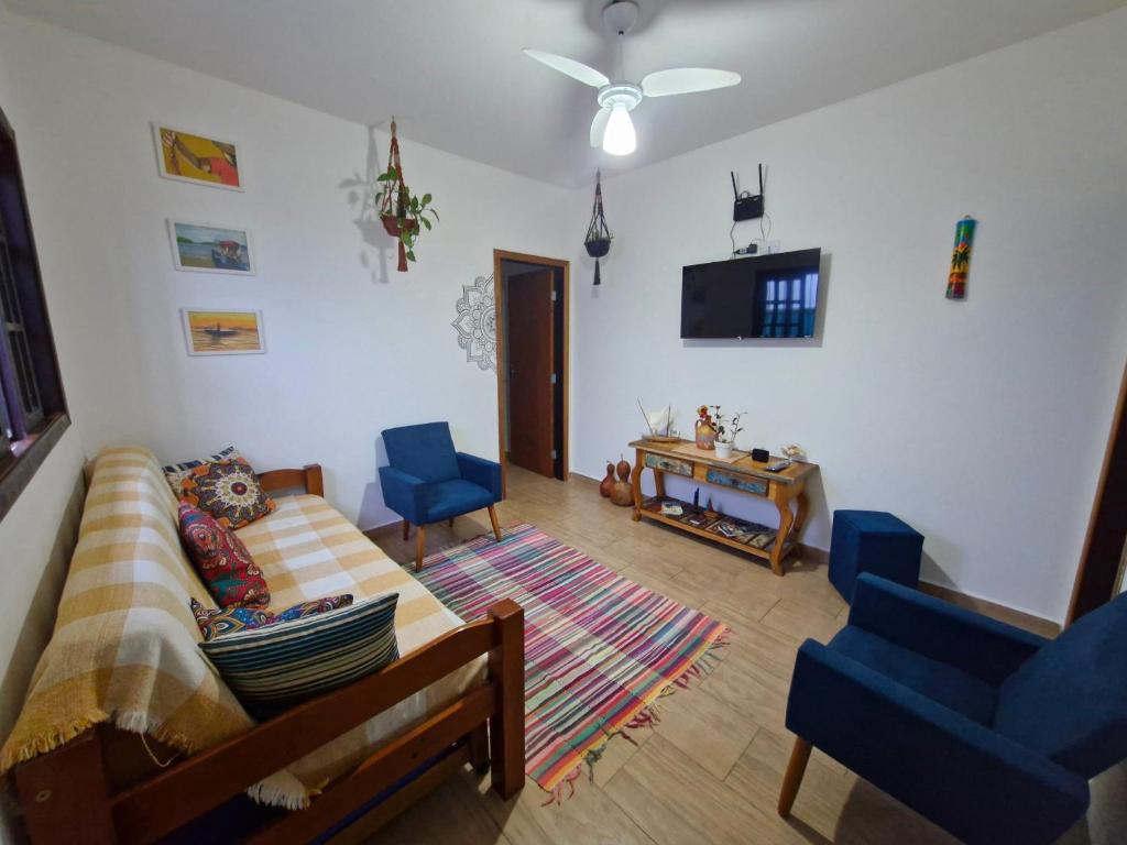 a living room with a bed and two blue chairs at A Ver o Mar Guest House in Caraguatatuba