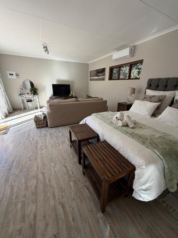 a bedroom with a large bed and a couch at Olive Branch Cottage off grid in Benoni