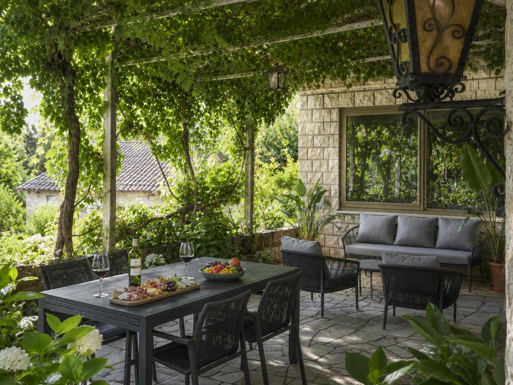 a patio with a table and chairs and a couch at Cozy house Luana in Lopud