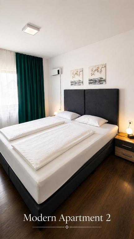 a large white bed in a bedroom with green curtains at Modern Apartment 2 in Brčko