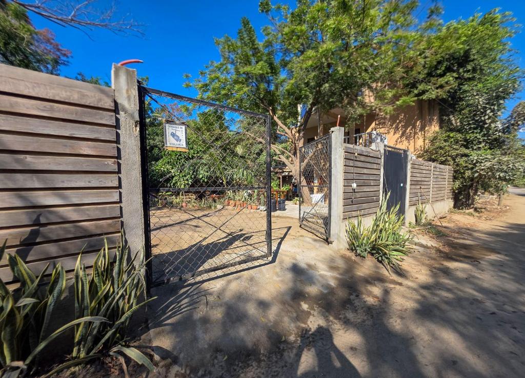 a gate in a fence with a sign on it at Zipolite Maracuya Hostel & Rooms in Zipolite