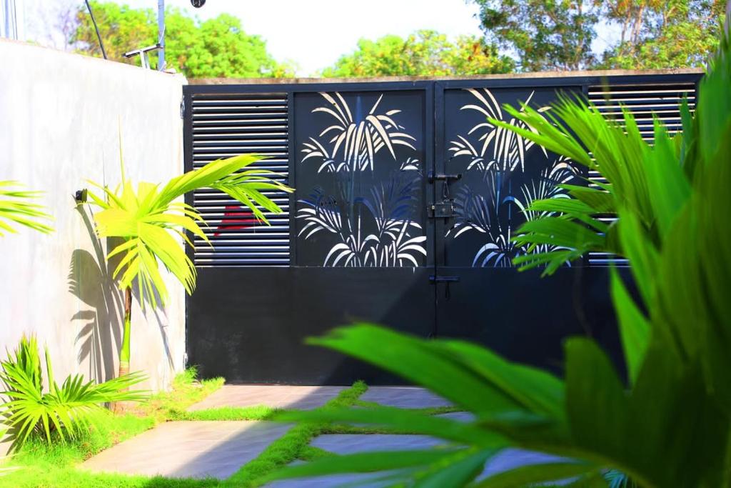 a black gate with a mural of palm trees on it at Dream Assinie V in Mafia