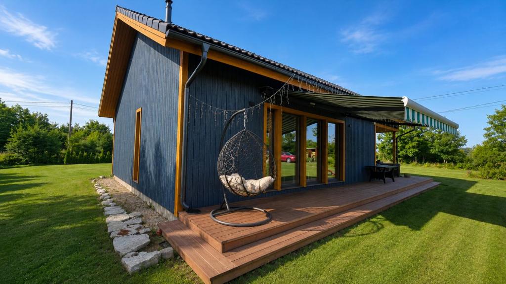 a small blue house with a large deck at Kaasaegne puhkemaja in Kersalu