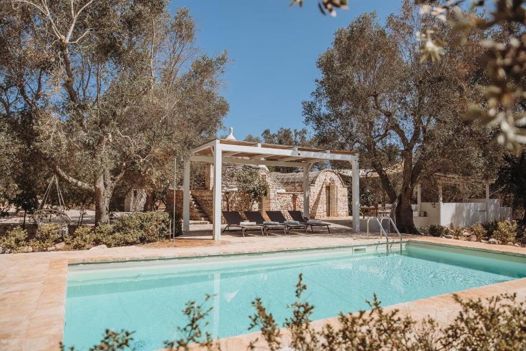 a swimming pool with a gazebo next to a house at Trullo Serenità Charming Trullo with Private Pool in Apulië in Ceglie Messapica