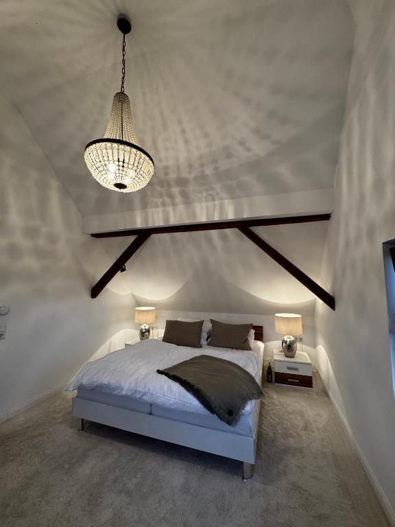 a bedroom with a bed and a chandelier at GENUSSZEIT Cottage in Udenhain