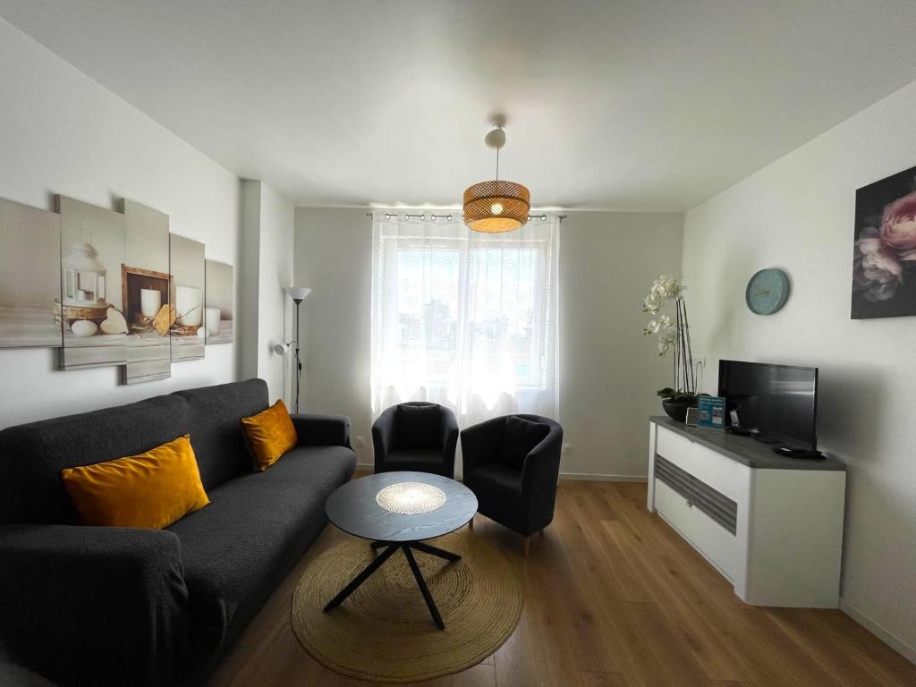 a living room with a couch and a table at Appartement Fleur De Houblon in Schiltigheim