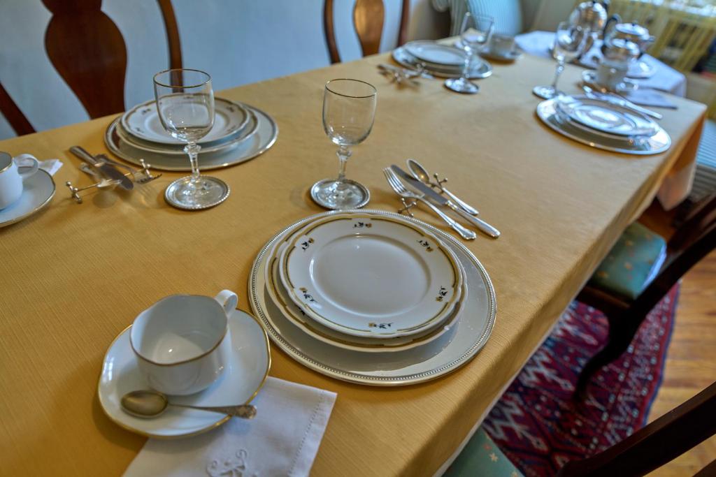 a table with plates and wine glasses on it at A Casa Armenia B&B in Turin