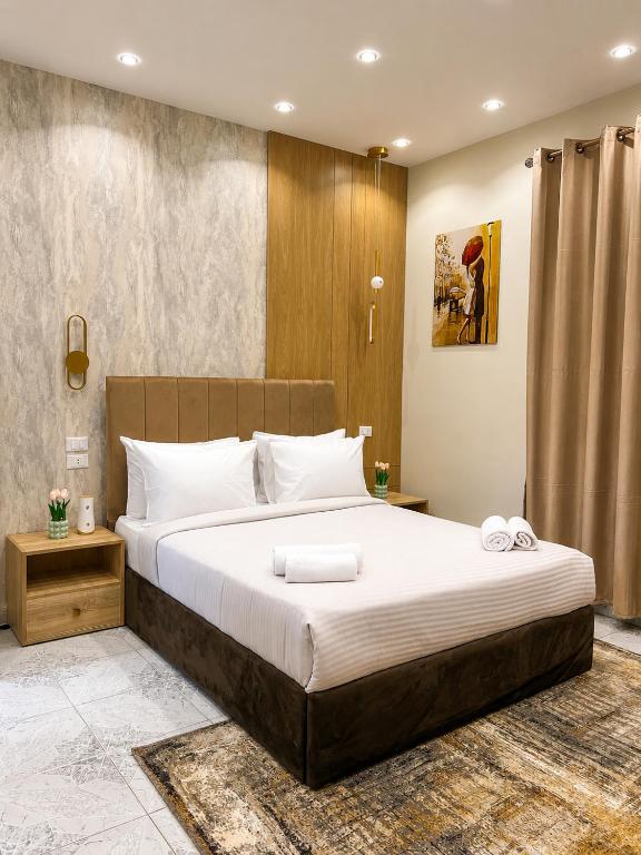 a bedroom with a large bed with white sheets at Tahrir Residence -"Marriage Certificate Required for Couples" in Cairo