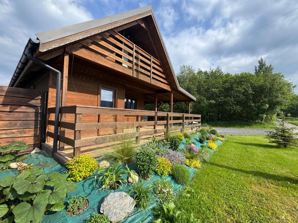 a wooden house with a garden in front of it at Gołąbek Stronie Śląskie in Stronie Śląskie