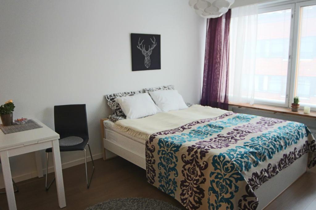 a bedroom with a bed and a table and a desk at Jaakonkatu City Apartment in Rovaniemi