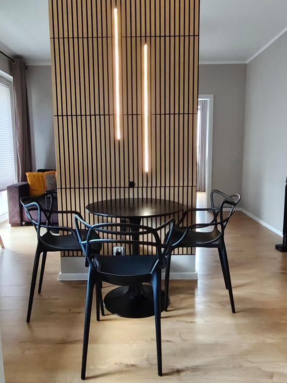 a dining room with a black table and chairs at Apartament Łąkoszyn Kutno in Kutno