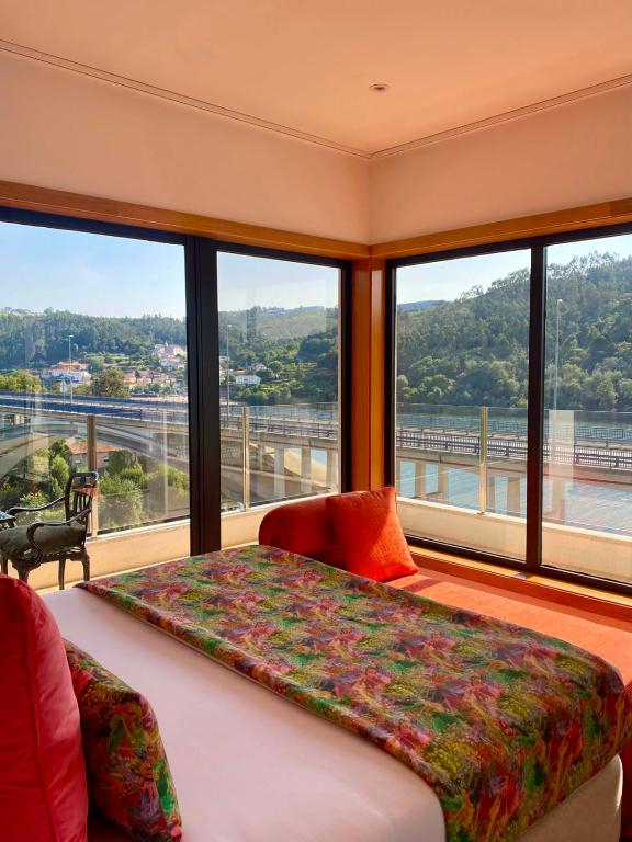 ein Schlafzimmer mit einem Bett und einem großen Fenster in der Unterkunft Estrelas do Douro in Gondomar